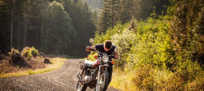 道の途中でバイクを押す男性